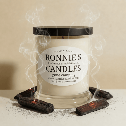 Natural soy candle emitting a smokey fragrance, perfect for creating a gone camping ambiance at home.
